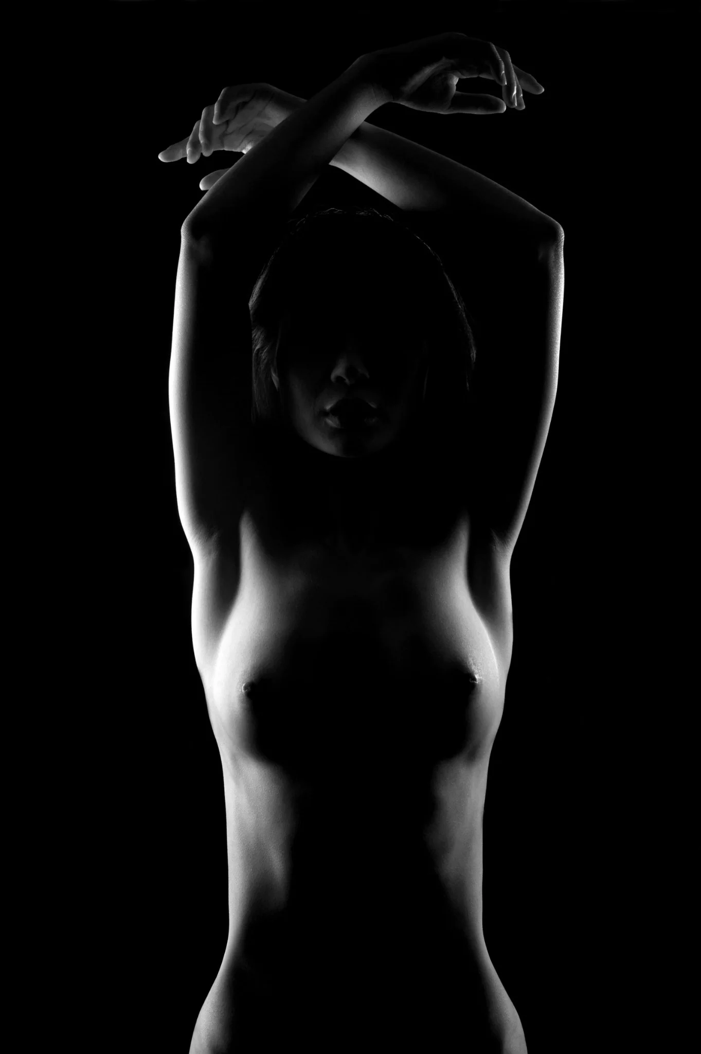 Abstract black and white figure study where light and shadow transform the human form into sculptural shape.